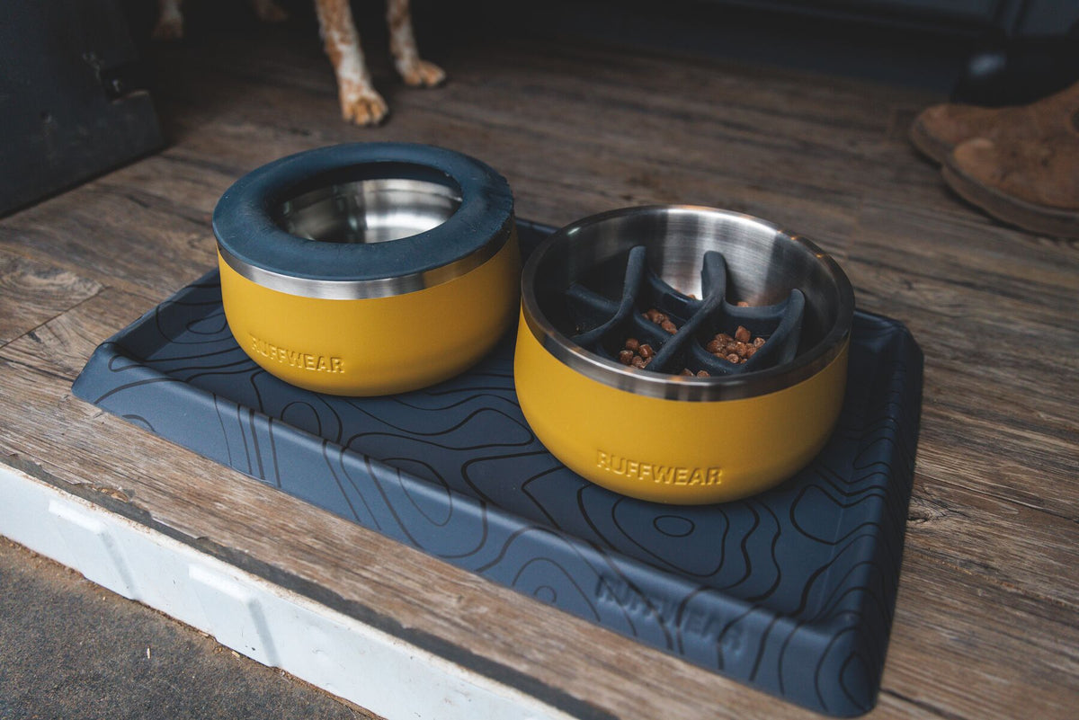 Two Ruffwear Basecamp Bowls with Slow Feeder Inserts fitted on a Basecamp Mat outdoors